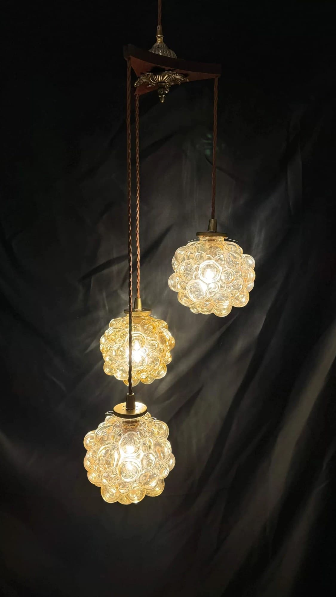 Three textured glass pendant lights hanging at different heights