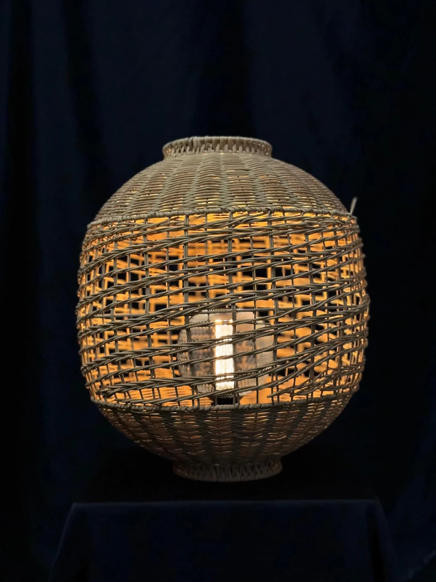 Woven cane pendant lamp lit from inside